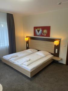 a large bed in a room with two lights on it at Hotel Biedermeier in Dortmund