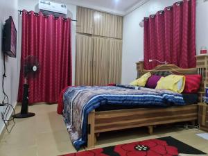 a bedroom with a bed with red curtains at Smart 3 bed apartment with fast Wi-Fi & 24hr light in Abuja +30 photos