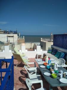a patio with a table and chairs and the beach at Dar Mussarat in Essaouira