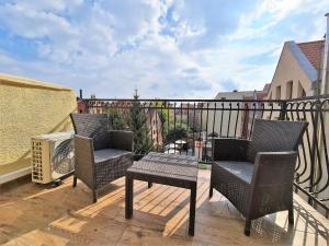 a patio with two chairs and a table on a balcony at Apartamenty WW in Toruń