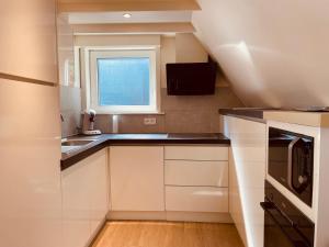 a small kitchen with white cabinets and a window at Casa Monica in Malmedy