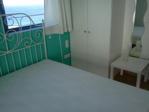 a bedroom with a bed and a window with the ocean at Dimitris House in Karistos