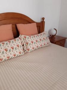 ein Bett mit Kissen darüber mit in der Unterkunft Apartamento Batalha - Quarteira, Algarve, Portugal in Quarteira