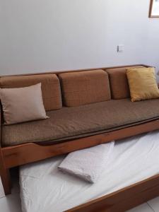 ein braunes Sofa mit Kissen auf dem Bett in der Unterkunft Apartamento Batalha - Quarteira, Algarve, Portugal in Quarteira