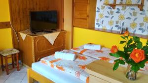 Un dormitorio pequeño con una cama y un televisor. en Csobogó Vendégház, en Eger