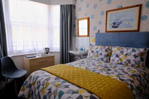 1 dormitorio con cama y lavamanos en Ainsley Court Guest House, en Scarborough