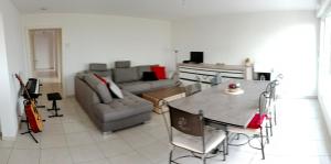 een woonkamer met een tafel en een bank bij Chambre #1 dans appartement partagé - Proche des Vosges in Thann