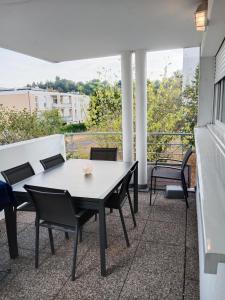patio con mesa y sillas en el balcón en Chambre #1 dans appartement partagé - Proche des Vosges, en Thann