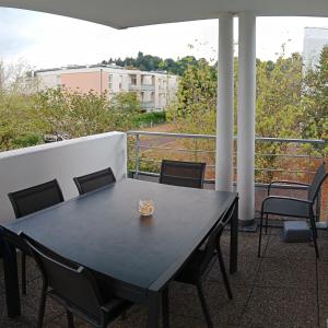 坦恩的住宿－Chambre #1 dans appartement partagé - Proche des Vosges，阳台上配有一张黑色的桌子和椅子