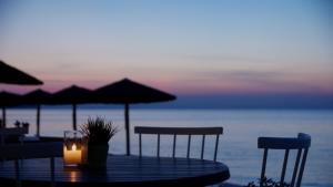 a table with chairs and umbrellas and a candle at Golden Star City Resort in Perea