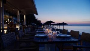 a wooden table with plates and glasses on top of the ocean at Golden Star City Resort in Perea