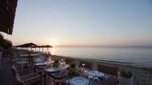 a table on the beach with the sunset in the background at Golden Star City Resort in Perea