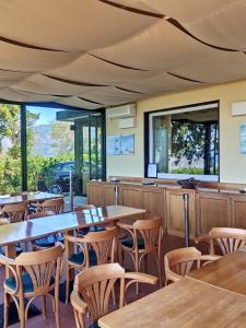 a restaurant with wooden tables and chairs and windows at Relais San Rocco in Sestri Levante
