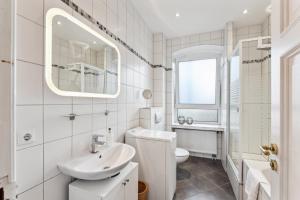 a white bathroom with a sink and a toilet at Bright 3-room apartment near Prenzlauer Berg in Berlin +12 photos