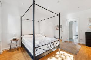 een slaapkamer met een zwart hemelbed in een kamer bij Bright 3-room apartment near Prenzlauer Berg in Berlijn