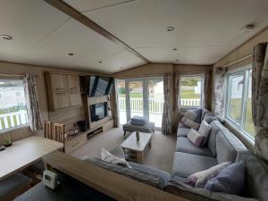 an rv living room with a couch and a tv at Aurora Way 81 in Lossiemouth