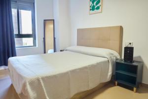 a bedroom with a bed with a white bedspread at Alojamiento Particular in Almería +13 photos