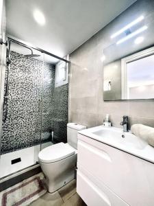 a bathroom with a toilet and a sink and a mirror at Apartament Bonaire in L'Escala