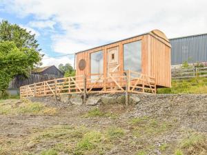 a wooden tiny house sitting on top of a field at The Sawyers Hut-uk39775 in Trefeglwys