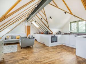 an attic kitchen and living room with white cabinets at Russets in North Weald