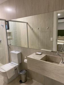 uma casa de banho com um lavatório, um WC e um espelho. em HOTEL CORTESE em Teresina