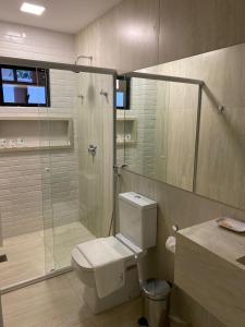 uma casa de banho com um WC e uma cabina de duche em vidro. em HOTEL CORTESE em Teresina