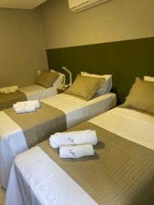 a room with three beds with towels on them at HOTEL CORTESE in Teresina