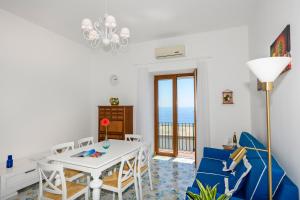 a living room with a dining room table and chairs at Casa Rispoli Praiano in Praiano