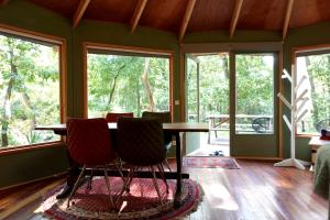 a dining room with a table and chairs and windows at Woeste Hoogte - Groesbeek in Groesbeek