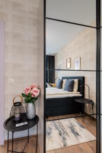 a bedroom with a bed and two tables and a mirror at New Stylish 1-bedroom Flat in Business District in Sofia