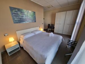 Un dormitorio con una cama blanca y una pintura en la pared en LA BUSSOLA, en Badia Polesine