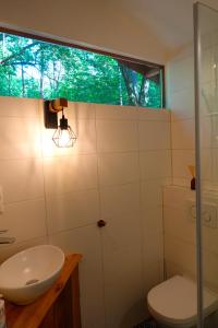 a bathroom with a toilet and a sink and a window at Panorama Hut in Groesbeek