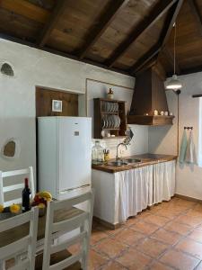 a kitchen with a white refrigerator and a counter at Finca Los Ciruelos Casas Rurales in Icod de los Vinos