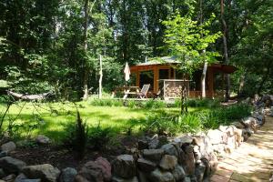 a log cabin in the woods with a stone wall at Panorama Hut in Groesbeek