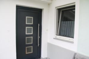 una puerta negra en un edificio blanco con una ventana en Ferienhaus Blaukovitsch en Weiz