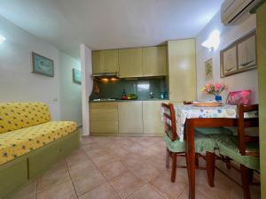 a living room with a table and a kitchen at Sardegna Beach Cala Reale in Santa Marinella
