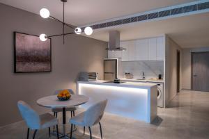 a kitchen with a table and some chairs and a counter at Steigenberger Residence Doha in Doha