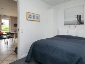 a bedroom with a bed and a table in a room at Holiday home Hjørring IV in Lønstrup