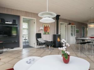 a living room with a table and a fireplace at Holiday home Hjørring IV in Lønstrup