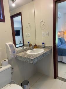 uma casa de banho com um lavatório, um WC e um espelho. em Villas do Pratagy Jambo I com Jacuzzy em Maceió