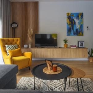 a living room with a yellow chair and a table at Vila Monia in Zvornik