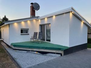 a house with two chairs sitting on a patio at Bungalow Lange in Schwielochsee