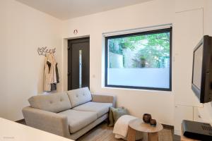 sala de estar con sofá y ventana en Stylishly furnished private home in a vibrant area, en Amberes