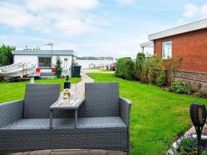un patio con 2 sillas y una mesa con una botella de vino en 2 person holiday home in Gr sten, en Gråsten