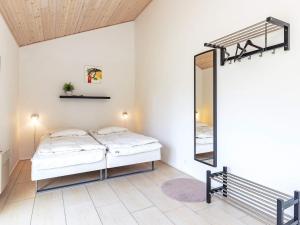 um quarto com uma cama e um espelho em Four-Bedroom Holiday home in Ålbæk 4 em Ålbæk