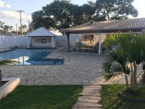 een achtertuin met een zwembad en een huis bij Chácara Recanto do Sossego em Mairinque-SP in Aluminio