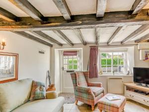 a living room with a couch and a tv at Bimble Cottage in Ingham