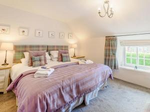 Ingham的住宿－Bimble Cottage，一间卧室设有两张床和窗户。