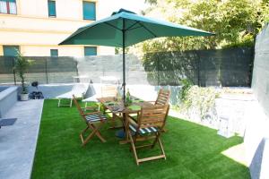 een tafel en stoelen met een parasol op het gras bij Mercante In Fiera in Verona