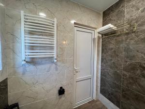 y baño con ducha, ventana y puerta. en Lola Apartments, en Tiflis 27 fotos más
